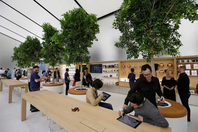 People try products in the "Genius Grove" at a new Apple store in San Francisco. The "Genius Bar" is being moved into a bigger area of the store with more tables and chairs.
