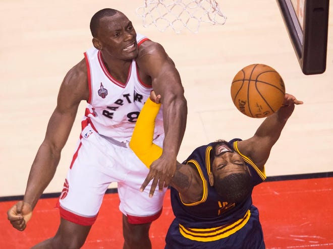 Raptors center Bismack Biyombo blocks a shot by the Cavaliers' Kyrie Irving.