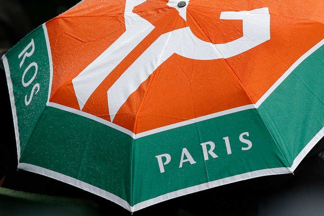 Raindrops sit on an umbrella with the Roland Garros logo as Japan's Kei Nishikori plays his first round match of the French Open tennis tournament against Italy's Simone Bolelli at Roland Garros stadium in Paris, France, Sunday, May 22, 2016. (AP Photo/Michel Euler)