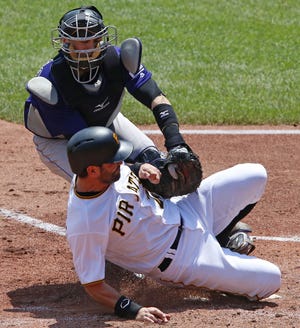 Rockies catcher Tony Wolters, top, tags out Pirates' catcher Francisco Cervelli who was attempting to score on a fielder's choice by Sean Rodriguez during the third inning in Pittsburgh on Monday.