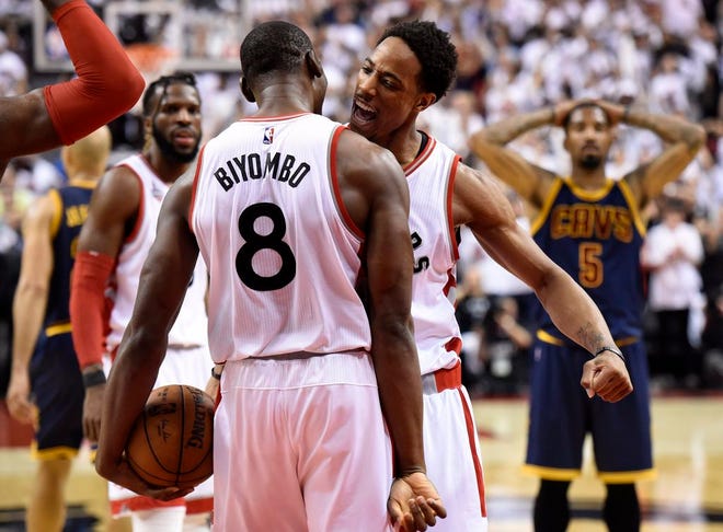 Toronto Raptors center-forward Bismack Biyombo and DeMar DeRozan celebrate during the last seconds of second half Eastern Conference final playoff basketball action against the Cleveland Cavaliers in Toronto on Monday, May 23, 2016. Toronto won, 105-99. (Frank Gunn/The Canadian Press via AP) MANDATORY CREDIT