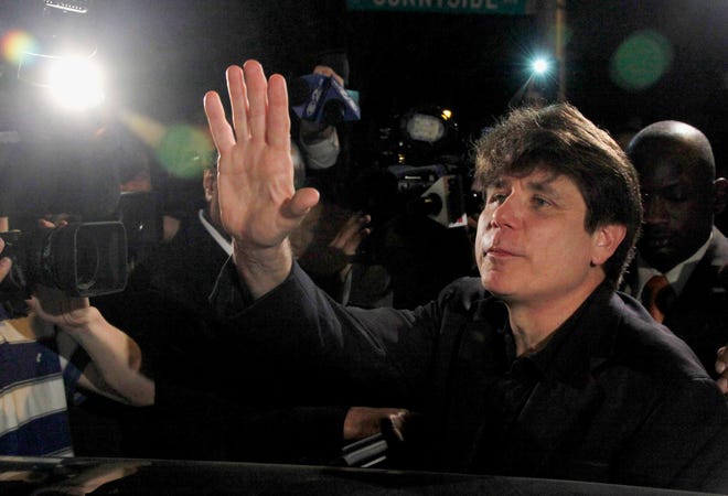 In this March 15, 2012, file photo, former Illinois Gov. Rod Blagojevich waves as he departs his Chicago home for Littleton, Colo., to begin his 14-year prison sentence on corruption charges. ASSOCIATED PRESS