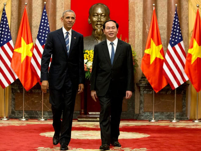 U.S. President Barack Obama, left, and Vietnamese President Tran Dai Quang walk to a meeting after shaking hands at the Presidential Palace in Hanoi, Vietnam, Monday.