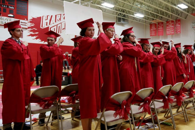 Members of the 2016 graduating class from Harmony High School, move their tassel from the right to the left during their graduation ceremony Sunday at Harmony High School in Farmington. The class is Harmony’s last graduating class.