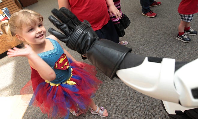 Annezly Moore, 4, gives a high-five to a stormtrooper at The Gaston County Public Library Comic Con. Photos by Mike Hensdill.