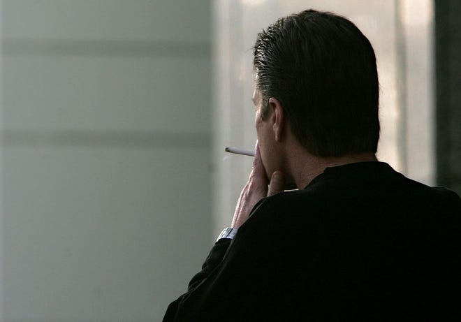 In this Dec. 13, 2005, file photo, an unidentified man smokes a cigarette in Sacramento, Calif. The adult smoking rate fell in 2015, with its largest annual decline in at least 20 years, according to a new government report. (AP Photo/Rich Pedroncelli, File)