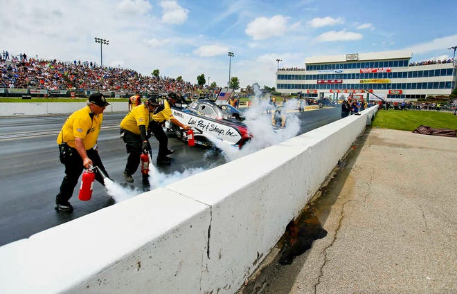 The Safety Safari tries to extinguish flames from Funny Car driver Tim Wilkerson's car after he hit the wall near the starting line during the semi finals of Sunday afternoon's NHRA Kansas Nationals at Heartland Park. The owner of Heartland Park Topeka won't be granted a more than $6 million reduction in property value.