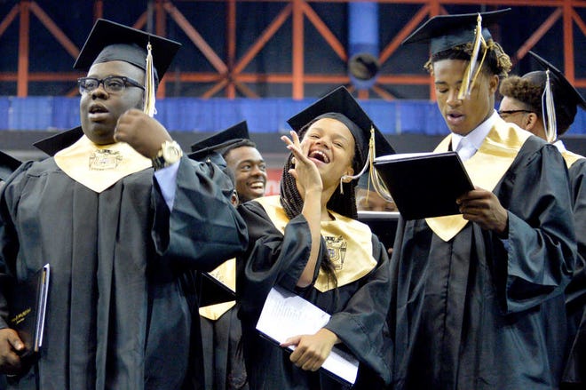 Butler High School graduates sing the school song at the end of the commencement ceremony at the James Brown Arena.