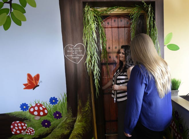 Beaver County Career and Technology Center students Cassie Lyons, center, and Tasha Crawford open the door to the new Toy Forest room on the top floor of the Ronald McDonald House in Pittsburgh on Wednesday. The room was designed and decorated by BCCTC students. They built shelves to hold toys, a bench and a tree made from PVC pipe and auto-body filler.
