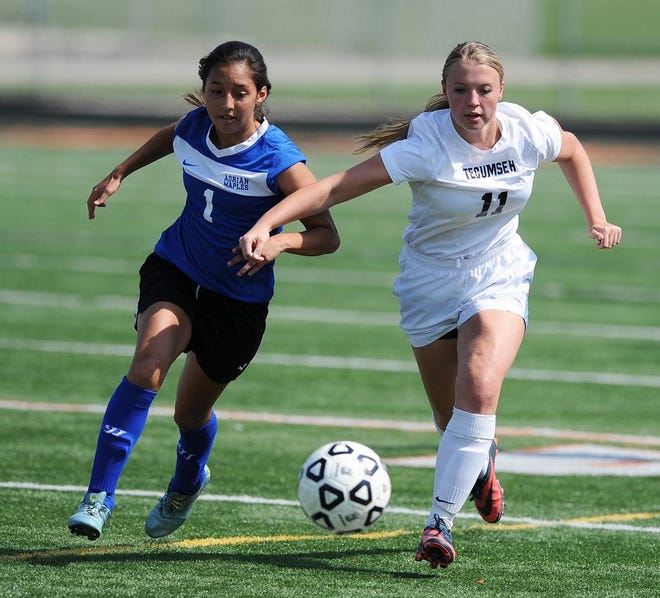 Adrian sophomore Vanessa Hernandez (1) and Tecumseh senior Melanie Hilderley chase down a loose ball during Tuesday's SEC White Division match.