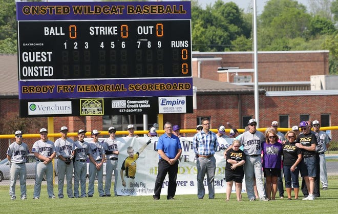 The Onsted High School baseball team participates Tuesday in a pregame ceremony to dedicate its new  scoreboard in memory of the late Brody Fry, who died in 2014.