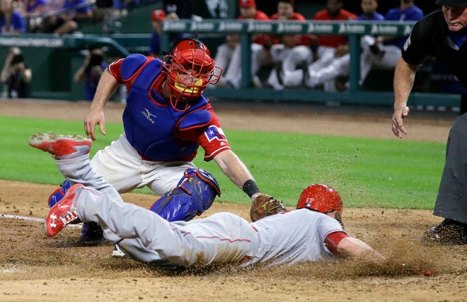 The Angels' Shane Robinson, bottom, is tagged out at home by Texas catcher Bryan Holaday during the Rangers' 4-1 win on Tuesday in Arlington.