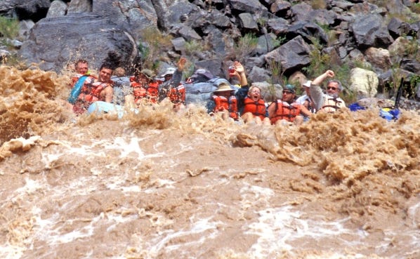 A 40-foot raft and its occupants are temporarily swamped by the muddy Colorado River at Hermit Rapid, which has some of the Grand Canyon's biggest waves and strongest hydraulics.