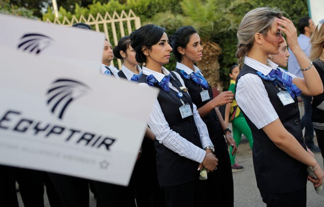 EgyptAir hostesses line up during a candlelight vigil for the victims of EgyptAir flight 804 in Cairo, Egypt, Thursday, May 26, 2016. The cause of Thursday's crash of the EgyptAir jet flying from Paris to Cairo that killed all 66 people aboard still has not been determined. Ships and planes from Egypt, Greece, France, the United States and other nations are searching the Mediterranean Sea north of the Egyptian port of Alexandria for the jet's voice and flight data recorders. (AP Photo/Amr Nabil)