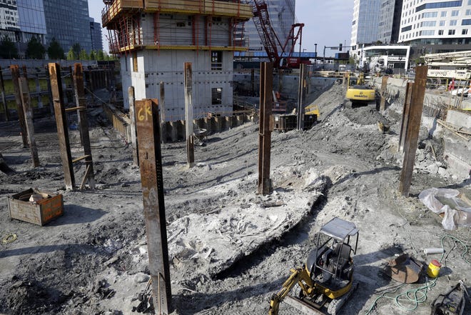 A shipwreck from the 1800s that has been uncovered during construction in the Seaport District is seen to the left of a construction vehicle, bottom, Wednesday, May 25, 2016, in Boston. According to city archaeologist Joe Bagley, it's the first time a shipwreck has been found in this section of Boston. Bagley says it appears the vessel was carrying lime, which was used for masonry and construction. (AP Photo/Elise Amendola)