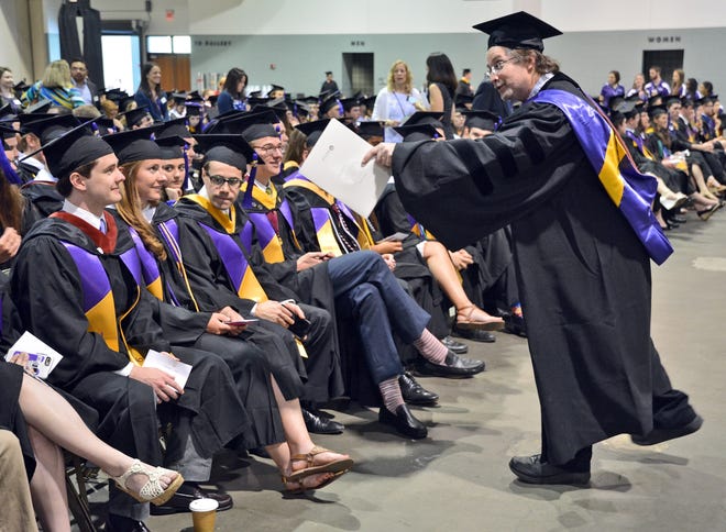 Holy Cross professor Ed Isser talks with the some honors graduates before the commencement ceremony Friday at the DCU Center. Photo/Chris Christo