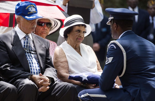 Staff Sgt. Jason Yallery of the 911th Airlift Wing Base Honor Guard presents the burial flag to Margaret Higginbotham, sister-in-law of Mitchell L. Higginbotham, as Mitchell's brother Robert, left, looks on during a burial ceremony for Sewickley native and Tuskegee Airman Mitchell L. Higginbotham on Saturday afternoon at the Sewickley Cemetery. Mitchell Higginbotham died at 94 on Feb. 14 in Rancho Mirage, Calif. He is one of seven Tuskegee Airmen from Sewickley and is the first to be buried at the memorial.