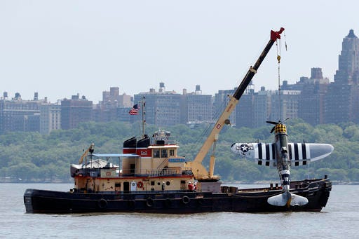 Officials remove a plane out of the Hudson River a day after it crashed, Saturday, May 28, 2016, in North Bergen, N.J. The World War II vintage P-47 Thunderbolt aircraft crashed into the river Friday, May 27 killing its pilot. (AP Photo/Julio Cortez)