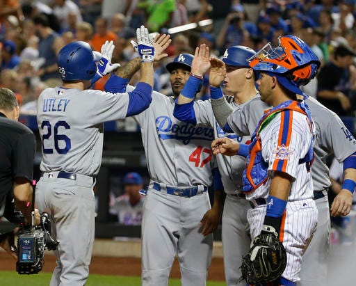 New York Mets catcher Rene Rivera (44) watches as Los Angeles Dodgers' Chase Utley (26) celebrates with teammates after hitting a grand slam home run during the seventh inning of a baseball game, Saturday, May 28, 2016, in New York. (AP Photo/Frank Franklin II)
