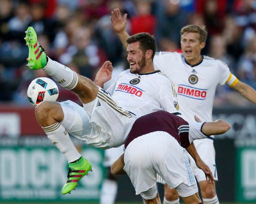 Philadelphia Union defender Ken Tribbett, left, collides with Colorado Rapids forward Luis Solignac, right, as Union midfielder Brian Carroll watches during the first half of an MLS soccer match Saturday, May 28, 2016, in Commerce City, Colo. (AP Photo/David Zalubowski)