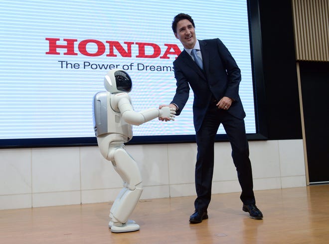 Canadian Prime Minister Justin Trudeau meets Honda Robot Asimo as he visits Honda Motor Co. headquarters in Tokyo, Japan, on Tuesday. Sean Kilpatrick/The Canadian Press via AP