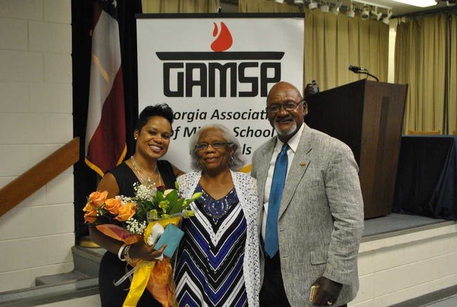 Riverside Middle School principal stands with her mother and father after being awarded on Thursday.