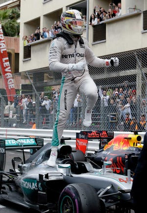 Mercedes driver Lewis Hamilton of Britain leaps in the air as he celebrates after winning the Monaco Formula One Grand Prix in Monaco, Sunday, May 29, 2016. (AP Photo/Claude Paris)