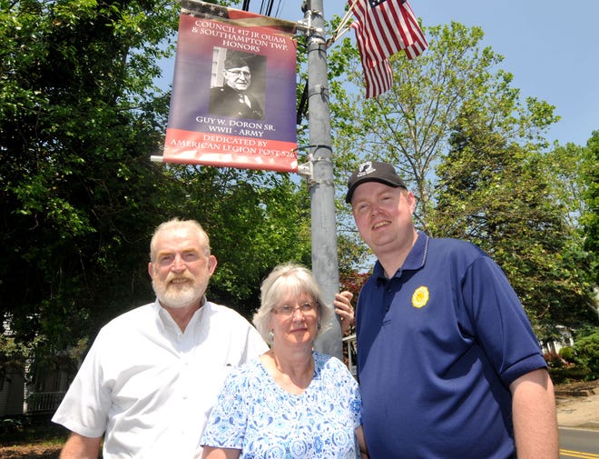 Frank Hicks, a U.S. Air Force veteran who served during Vietnam stands with his wife, Grace, and son Jeff Hicks on Main Street in Southampton on Friday, May 27, 2016. The three stand under a banner for Guy Doron Sr. who served in WWI in the Army.