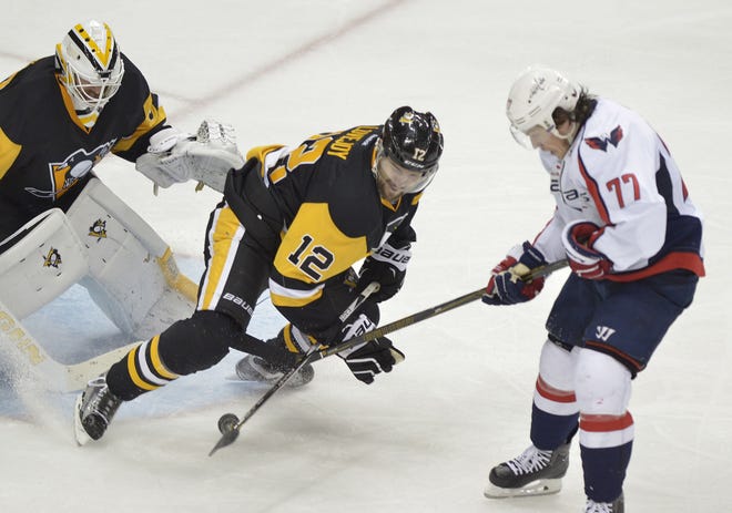 Ben Lovejoy (12) defends against a shot by T.J. Oshie (77) in front of Penguins goalie Matthew Murray during the third period of Game 4 in the second round of the 2016 NHL Stanley Cup Playoffs between the Washington Capitals and the Pittsburgh Penguins on Wednesday at Consol Energy Center in Pittsburgh.