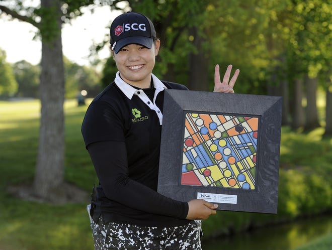 Ariya Jutanugarn, of Thailand, stands with the LPGA Volvik Championship trophy after winning the golf tournament at the Travis Pointe Country Club, Sunday, May 29, 2016 in Ann Arbor, Mich. Jutanugarn is holding up three fingers to signify that she has won three LPGA tournaments in a row. (AP Photo/Jose Juarez)