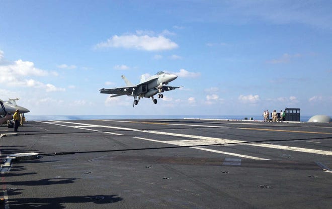 FILE - In this Friday, April 15, 2016 file photo, an FA-18 jet fighter lands on the USS John C. Stennis aircraft carrier in the South China Sea while U.S. Defense Secretary Ash Carter visited the aircraft carrier during a trip to the region. American ships and fighter jets maneuvering across the South China Sea and the Sea of Japan represent the "new normal" in U.S.-Pacific relations despite rising tensions with China and Russia. U.S. moves in recent months have led to angry protests from Beijing and Moscow. They say the Obama administration is fueling unrest in the Asia Pacific, and is conducting for illegal and unsafe transit in the region. (AP Photo/Lolita C. Baldor, File)