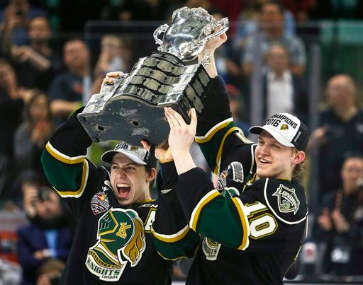 London Knights' Mitchell Marner, left, and Christian Dvorak lift the Memorial Cup as they celebrate their overtime victory in CHL Memorial Cup championship game hockey action against the Rouyn-Noranda Huskies in Red Deer, Canada, Sunday, May 29, 2016. (Jeff McIntosh/The Canadian Press via AP) MANDATORY CREDIT