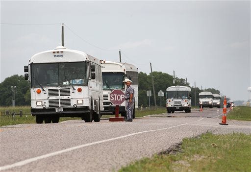 Texas Department of Criminal Justice prisoners are evacuated from the Terrell and Stringfellow Units Sunday, May 29, 2016, in Rosharon, Texas. Heavy rains have caused flooding in the Brazos River and prompted prison officials to start evacuating about 2600 inmates. "We're just trying to get ahead of it," Major Richard Babcock said. (Jon Shapley/Houston Chronicle via AP)