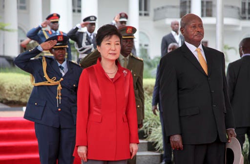 South Korea's president Park Geun-hye, left, and Uganda's President Yoweri Museveni, right, stand for the national anthems at State House in Entebbe, Uganda, Sunday, May 29, 2016. Uganda and South Korea have signed cooperation agreements that officials hope will lead to transfer of technology as Uganda tries to implement an ambitious industrialization program. (AP Photo/Stephen Wandera)