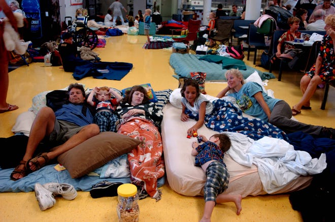 A family from Englewood takes shelter in the cafeteria at North Port High School on Aug. 13, 2004 before Hurricane Charley hit Charlotte County.