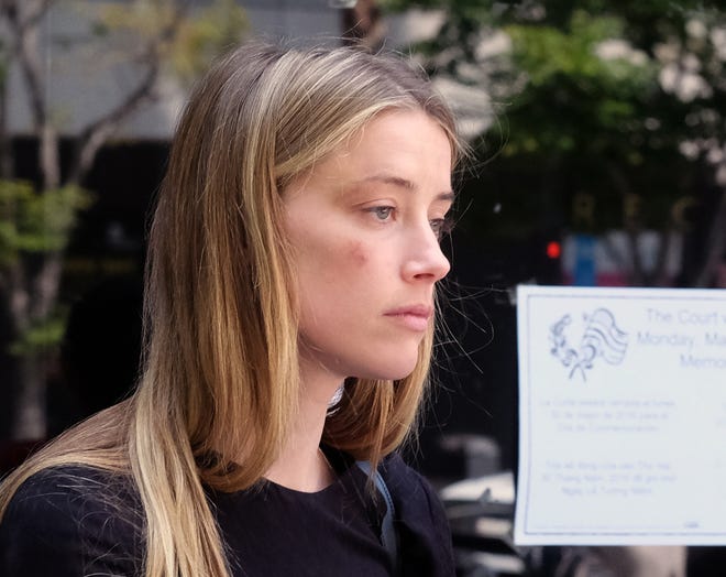 Actress Amber Heard leaves Los Angeles Superior Court court on Friday after giving a sworn declaration that her husband, Johnny Depp, threw her cellphone at her during a fight Saturday, striking her cheek and eye. The judge ordered Depp to stay away from his estranged wife and ruled that Depp shouldn't try to contact Heard until a hearing is conducted on June 17. (AP Photo/Richard Vogel)