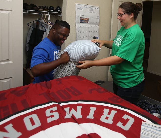 CrossingPoints staff member Anna Kathryn Bonner, right, helps Cameron Tubbs of Marion, Ala., put a pillow into a pillowcase as they make his bed at Lakeside East dorms on the University of Alabama campus on Sunday. Tubbs had arrived for UA's CrossingPoints nine-week Summer Bridge program, which allows students with intellectual disabilities to experience college life.