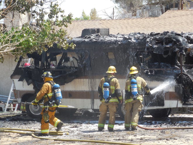 County Fire crews continue dousing an RV after it became fully engulfed in flames Sunday morning in Victorville. Shea Johnson, Daily Press.