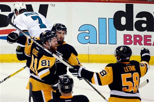 Pittsburgh Penguins' Nick Bonino, center, celebrates his game-winning goal against the San Jose Sharks with Phil Kessel (81) and Kris Letang (58) during the third period in Game 1 of the Stanley Cup final series Monday, May 30, 2016, in Pittsburgh. (AP Photo/Gene J. Puskar)