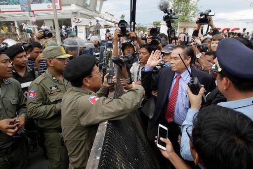 Ho Vann, second right, a lawmaker of Cambodia National Rescue Party (CNRP), talks with police officers near the CNRP headquarters on the outskirts of Phnom Penh, Cambodia, Monday, May 30, 2016. Police in Cambodia blocked an opposition protest march on Monday, but avoided violence by allowing a convoy of opposition lawmakers to drive through to present a petition complaining of government intimidation to the king. (AP Photo/Heng Sinith)