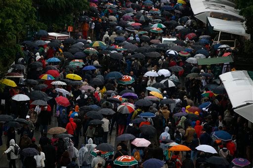 People leave the Roland Garros stadium, Monday, May 30, 2016 in Paris. French Open organizers have announced the cancellation of all matches Monday at Roland Garros because of persistent rain forecast to last all day. (AP Photo/Alastair Grant)