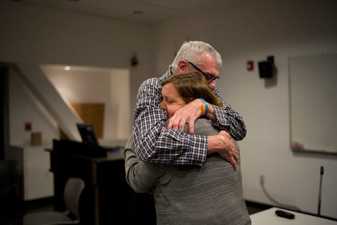 In this Monday, May 23, 2016 photo, Mandy Pifer is comforted by Rick Mogil, program director for Didi Hirsch's suicide prevention and bereavement services, at a crisis response team meeting in Los Angeles. Nearly six months ago, her boyfriend, Shannon Johnson, was one of 14 people killed in the San Bernardino terrorist attack. As a responder with the Los Angeles mayor's crisis response team, Pifer has spent the last six years comforting others in the aftermath of tragedy. But after the attack, Pifer found herself dealing with a crushing, overwhelming sadness. (AP Photo/Jae C. Hong)