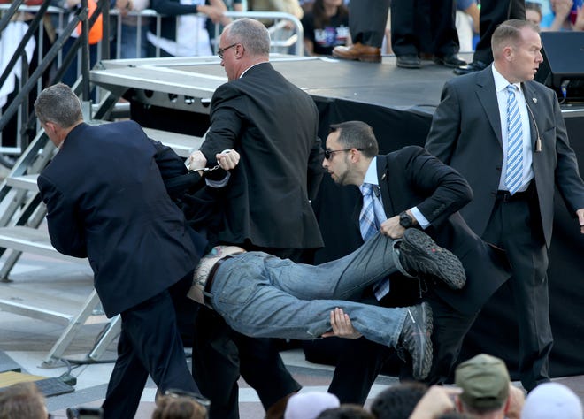 Secret Service agents remove a man from the crowd during a campaign rally for Democratic presidential candidate, Sen. Bernie Sanders, I-Vt., at Frank Ogawa Plaza in Oakland, Calif., on Monday, May 30, 2016. A group of animal rights activists briefly interrupted the Sanders rally in Northern California when they jumped barricades and tried to rush the podium. Sanders' security stopped the protesters before they could reach Sanders, who was addressing supporters at the rally and continued his speech within minutes of the disruption. (Anda Chu/Oakland Tribune via AP)