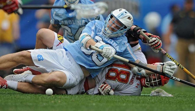 North Carolina defenseman Evan Connell (top) knocks down Maryland's Jack Lambert fighting for the ball in the title game. The Tar Heels won in overtime.