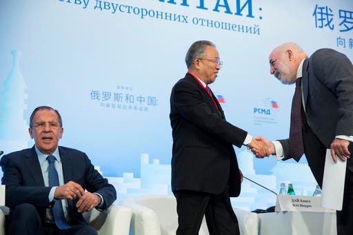 Chairman of the Chinese Chapter of the Russian-Chinese Committee of Friendship, Peace and Development Dai Bingguo, center, shakes hands with Russian businessman Viktor Vekselberg, as Russian Foreign Minister Sergey Lavrov, left, attends the Russian International Affairs Council in Moscow, Russia, Tuesday, May 31, 2016. The Russian International Affairs Council hosts a Russia-China conference ahead of Russian President Vladimir Putin's official visit to China in June. (AP Photo/Pavel Golovkin)