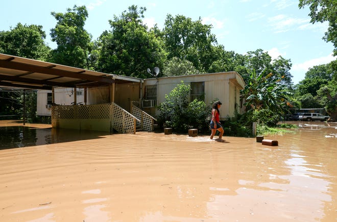 Irene Martinez, who lives near the Brazos River, leaves her flooded home Sunday, May 29, 2016, in Richmond, Texas. Martinez lives there with her two sons, and they are evacuating because the river is exprected to rise another several feet. (Jon Shapley/Houston Chronicle via AP)