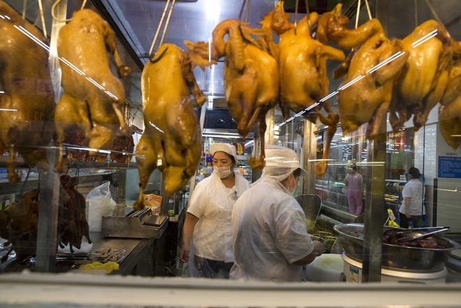 A worker prepares cooked ducks for sale at a Wal-Mart in Shenzhen, in southern China. Wal-Mart is shedding some of its American ways to attract customers in China. THE ASSOCIATED PRESS