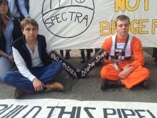 Martin Hamilton, 21, of Cambridge, and Ben Weilerstein, 22, of Medford, dressed as Luke Skywalker and Han Solo, respectively, use heavy hardware to lock themselves to the Spectra Energy’s West Roxbury Lateral gas pipeline construction site on Grove Street in West Roxbury. Courtesy photo