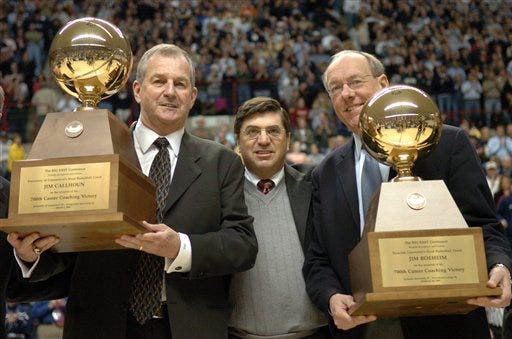 Connecticut coach Jim Calhoun, left and Syracuse coach Jim Boeheim, right, stand between Big East Commissioner Mike Tranghese, after they were presented with matching 700 winning game career high trophies before the start of a game in Storrs, Conn., Saturday, March 5, 2005. Connecticut won 88-70. (AP Photo/Steve Miller)