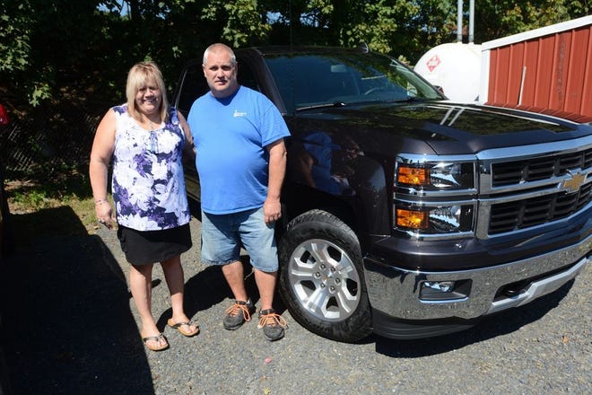 In this Sept. 17, 2015 photo, Joan Lechleitner and Kerry Titus, both of Pottsville, stand next to the 2015 Chevrolet Silverado 1500 Z71 the couple bought with money they won playing the Cash 5 lottery game in September 2015. The couple were charged Tuesday, May 31, 2016, along with two other former employees with stealing from the Agway store in Cressona that they bought the winning ticket from. (Nick Meyer/The Republican-Herald via AP)